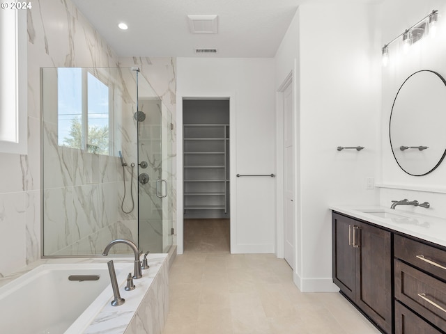 bathroom with tile patterned flooring, vanity, and independent shower and bath