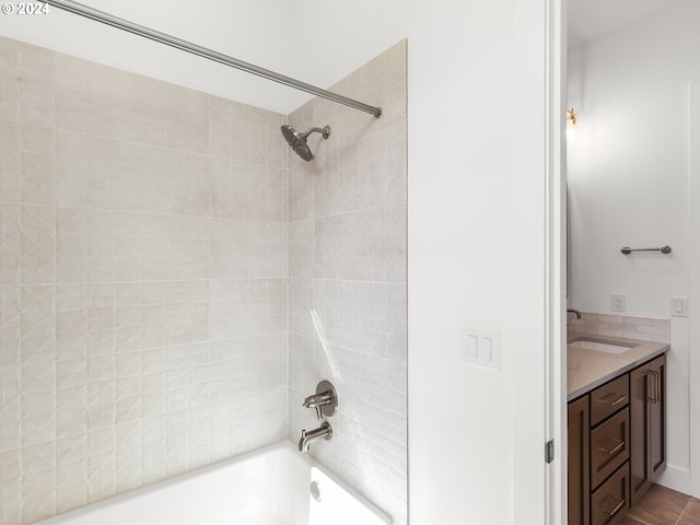 bathroom featuring vanity and tiled shower / bath