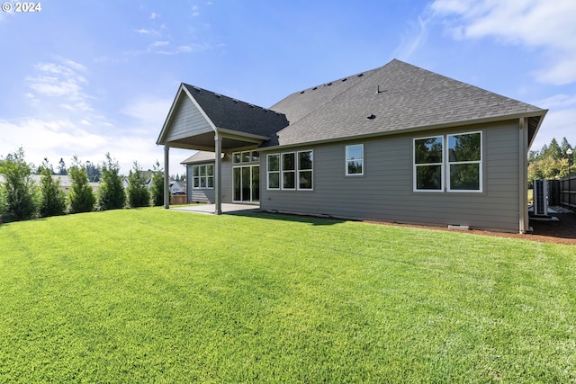 rear view of property featuring a lawn and a patio area