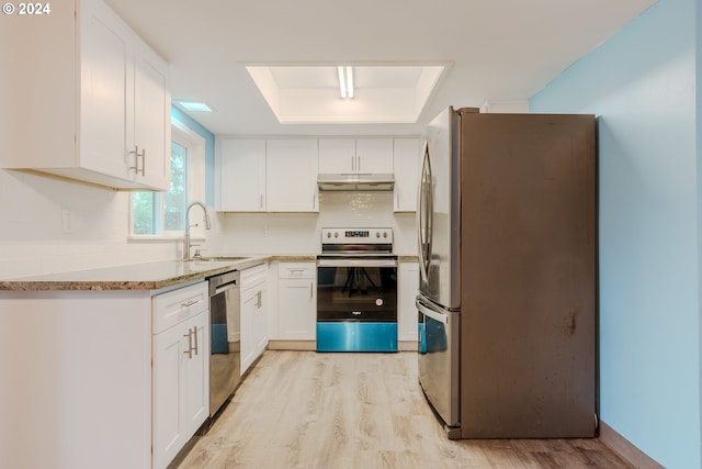 kitchen with a raised ceiling, sink, appliances with stainless steel finishes, light hardwood / wood-style floors, and white cabinetry