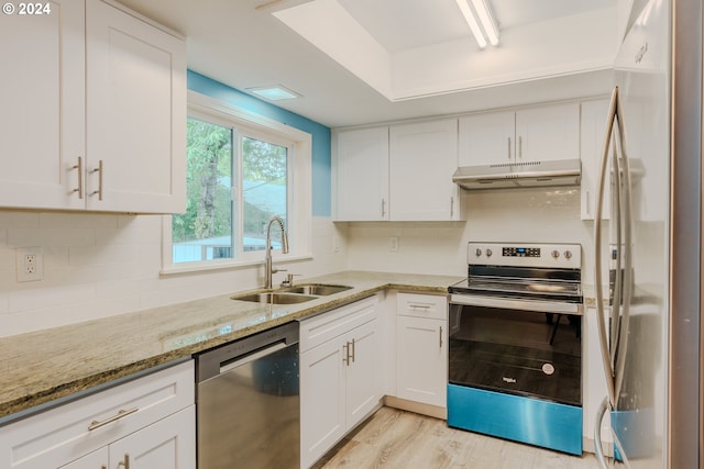 kitchen with white cabinets, light stone counters, sink, and stainless steel appliances