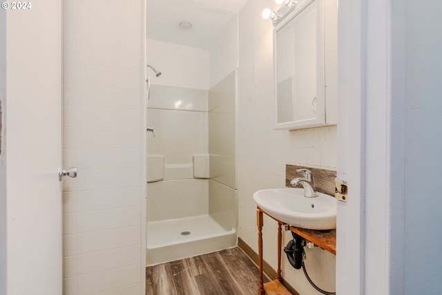 bathroom featuring hardwood / wood-style floors, a shower, and sink