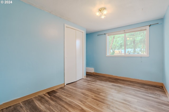 unfurnished bedroom featuring a closet and light hardwood / wood-style flooring