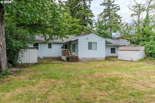 rear view of property with a yard and a storage unit