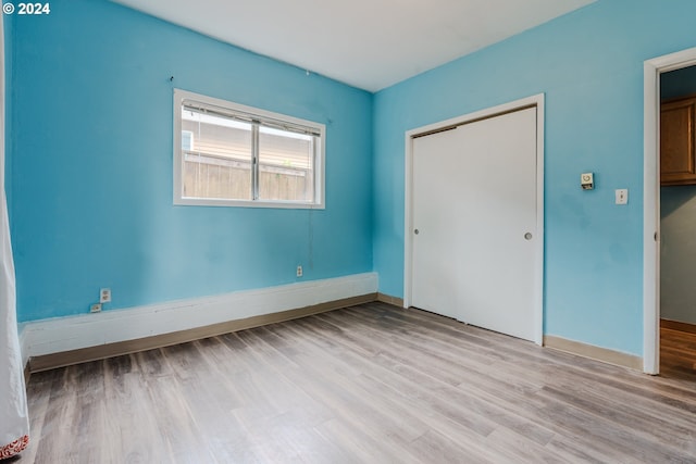 unfurnished bedroom with a closet and light hardwood / wood-style flooring