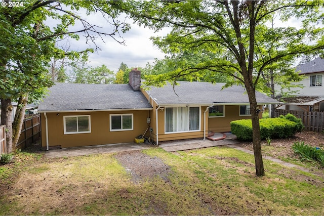 back of property featuring a yard and a patio area