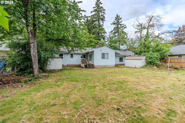 rear view of property featuring a shed and a lawn