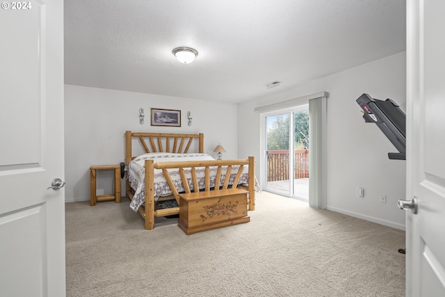 bedroom with a textured ceiling, light colored carpet, and access to outside