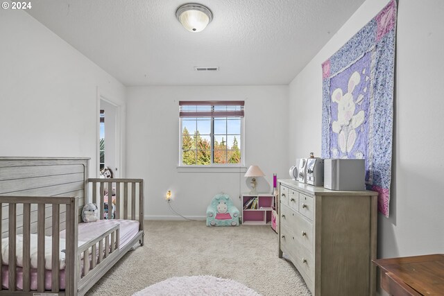 carpeted bedroom featuring a textured ceiling