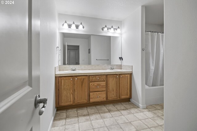 bathroom with vanity, a textured ceiling, and shower / tub combo