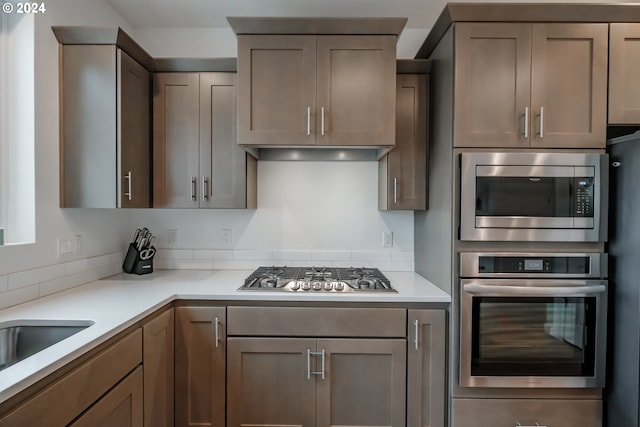 kitchen featuring extractor fan, stainless steel appliances, and sink