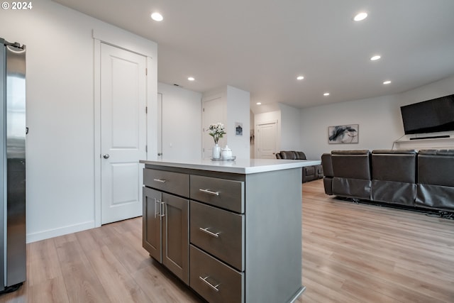 kitchen with stainless steel fridge, a center island, and light hardwood / wood-style floors