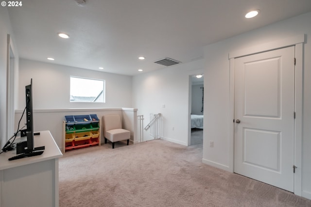 sitting room featuring light colored carpet