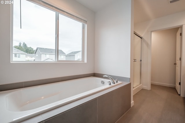 bathroom featuring plenty of natural light and independent shower and bath