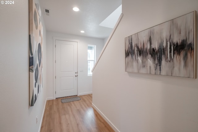 entryway featuring a skylight and light hardwood / wood-style flooring