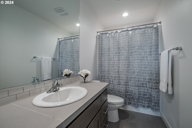 bathroom featuring vanity, toilet, and walk in shower