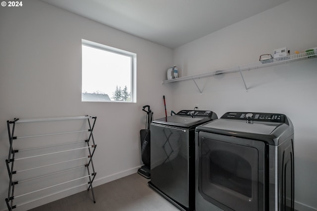 laundry room with hardwood / wood-style flooring and washer and clothes dryer