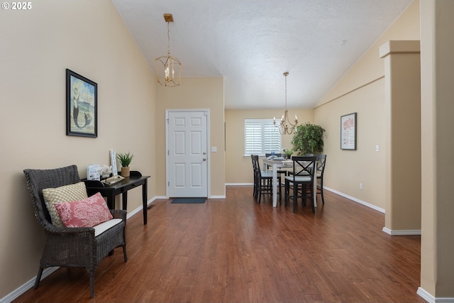 entrance foyer with baseboards, a notable chandelier, dark wood finished floors, and high vaulted ceiling