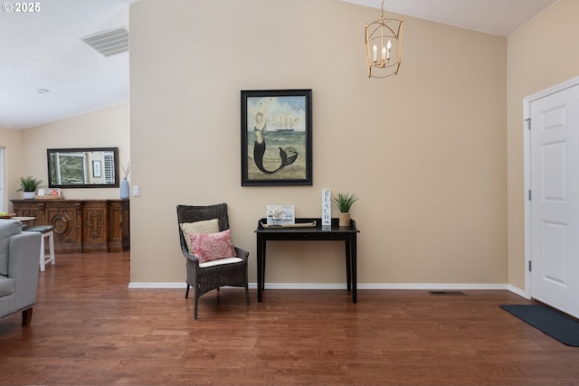 foyer entrance featuring wood finished floors, visible vents, baseboards, lofted ceiling, and a notable chandelier