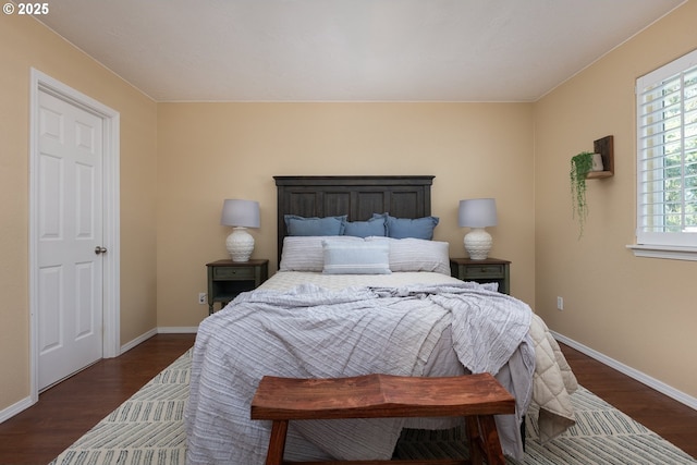 bedroom featuring baseboards and dark wood-style flooring