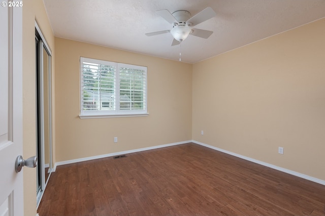 unfurnished bedroom featuring a closet, baseboards, visible vents, and dark wood-style flooring