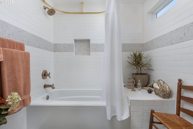 bathroom with tile walls and shower / tub combo