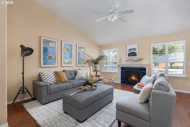 living area with a ceiling fan, lofted ceiling, plenty of natural light, and dark wood-style floors