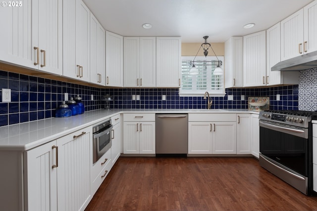 kitchen with under cabinet range hood, white cabinets, stainless steel appliances, and a sink