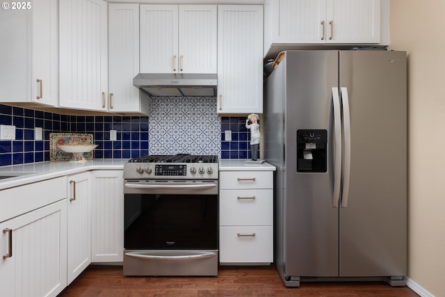 kitchen with under cabinet range hood, dark wood finished floors, stainless steel appliances, and light countertops