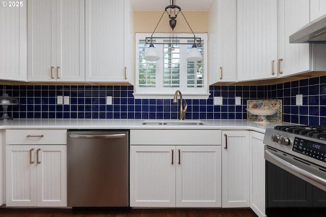 kitchen with a sink, under cabinet range hood, white cabinetry, stainless steel appliances, and decorative backsplash