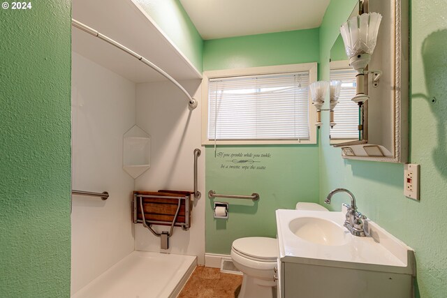 bathroom featuring a shower, vanity, and a healthy amount of sunlight