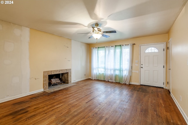 unfurnished living room with a fireplace, dark hardwood / wood-style flooring, and ceiling fan