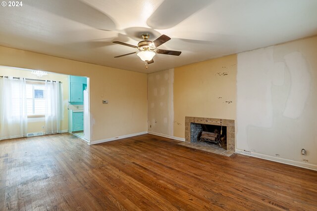 unfurnished living room with a fireplace, ceiling fan, and hardwood / wood-style floors