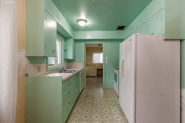 kitchen with white appliances, plenty of natural light, and sink