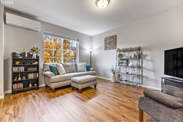 living room featuring a textured ceiling, a wall mounted AC, and wood-type flooring