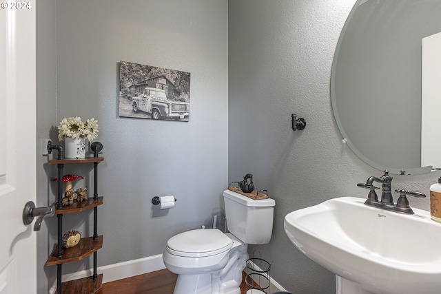 bathroom with hardwood / wood-style flooring, toilet, and sink