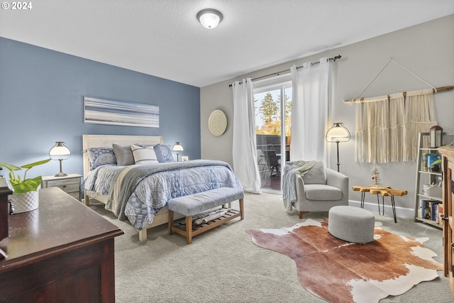 carpeted bedroom featuring access to exterior and a textured ceiling