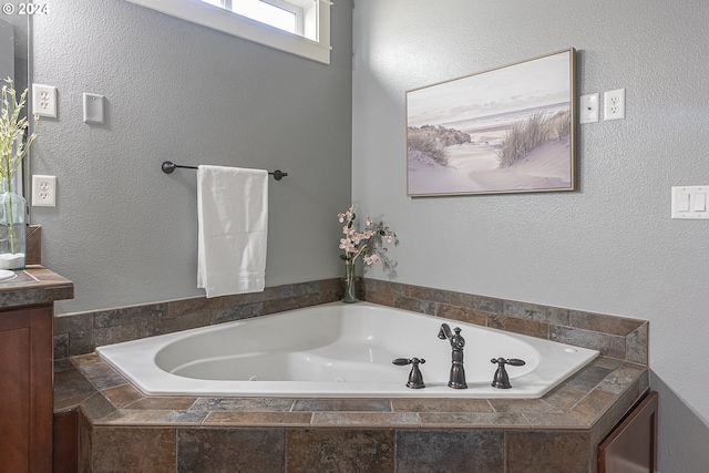 bathroom with a relaxing tiled tub and vanity