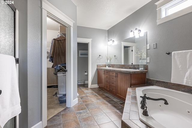 bathroom with a washtub, a textured ceiling, and vanity