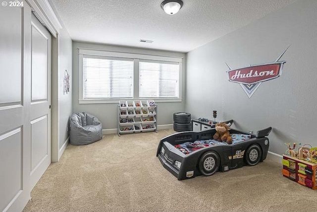 game room featuring a textured ceiling and light colored carpet