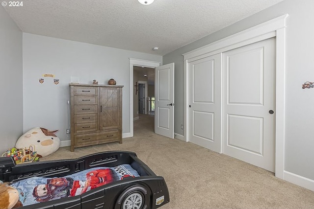 carpeted bedroom featuring a closet and a textured ceiling