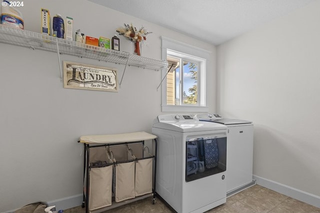 clothes washing area featuring tile patterned flooring and washing machine and clothes dryer