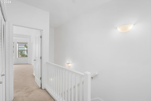 hall with light colored carpet