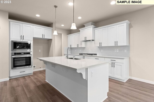 kitchen featuring a kitchen island with sink, appliances with stainless steel finishes, white cabinetry, and pendant lighting