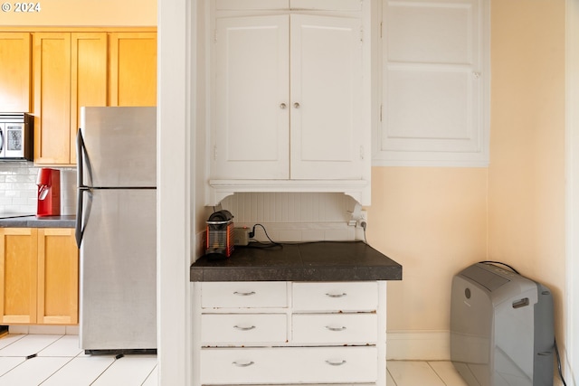 kitchen with decorative backsplash, light brown cabinets, stainless steel appliances, and light tile patterned floors