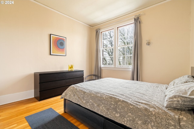 bedroom featuring hardwood / wood-style floors and ornamental molding