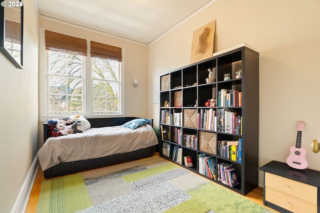 bedroom with wood-type flooring and ornamental molding