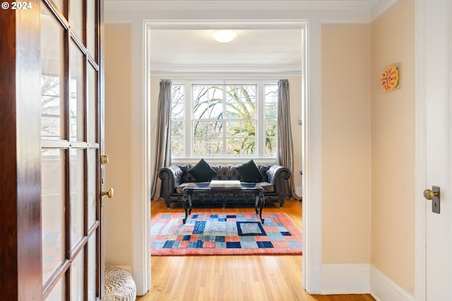 sitting room featuring ornamental molding and light hardwood / wood-style flooring