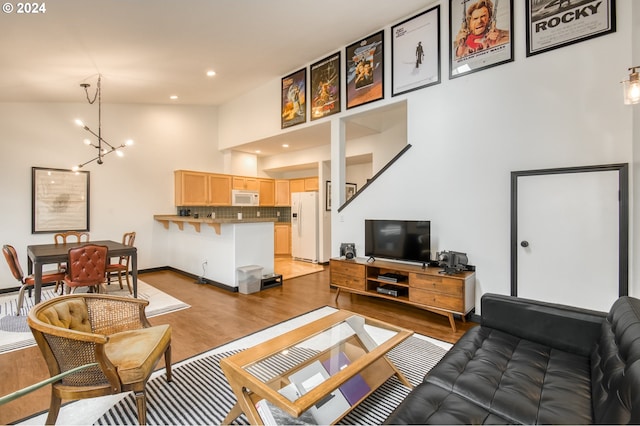 living room featuring hardwood / wood-style flooring, lofted ceiling, and a chandelier