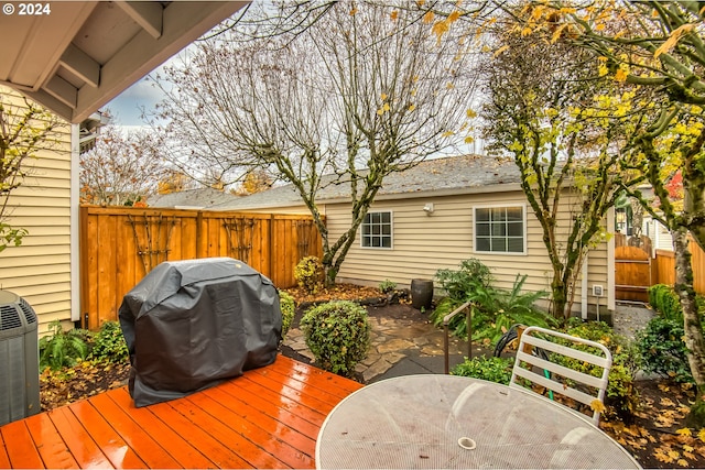 wooden terrace with central AC unit and area for grilling